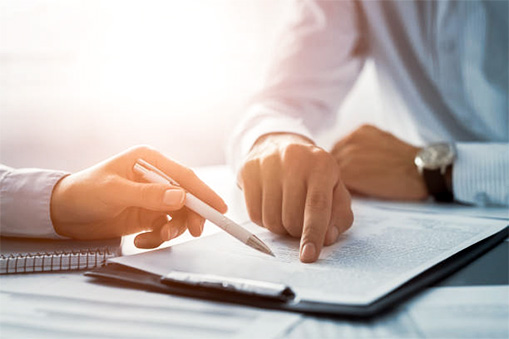 A tight shot of hands going over a particular point in the text of a written page on a clipboard, to illustrate negotiation and communication skills